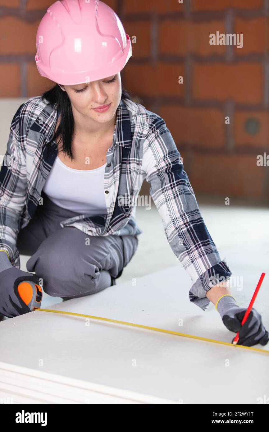 female construction worker at work measuring Stock Photo
