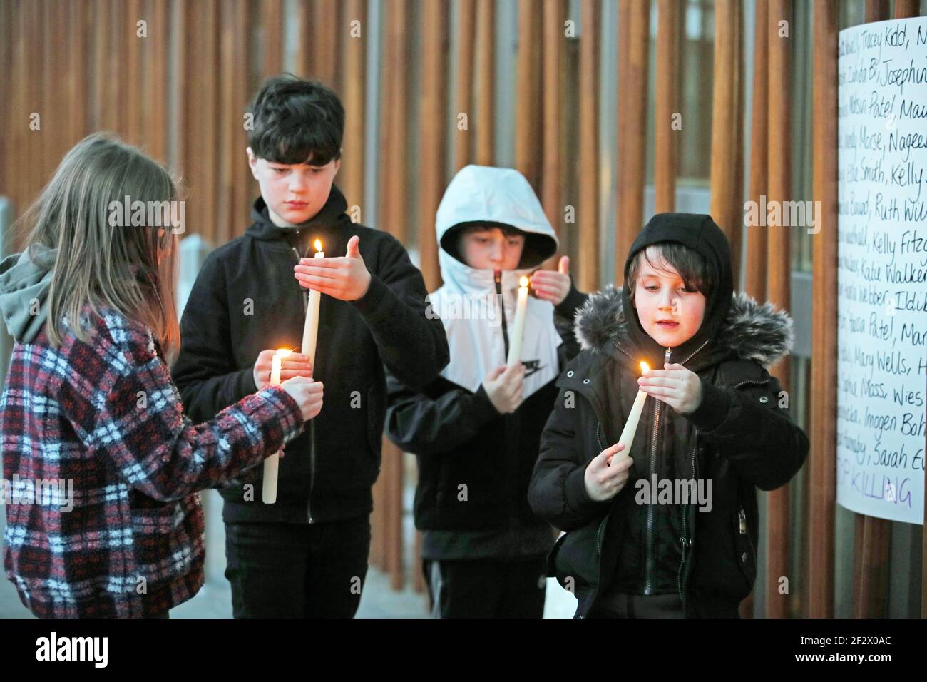 Note to eds: parental consent given. Young people light candles outside the Scottish Parliament after the Reclaim These Streets vigil for Sarah Everard in Edinburgh was cancelled. Serving police constable Wayne Couzens, 48, was charged on Friday evening with kidnapping and killing the marketing executive, who went missing while walking home from a friend's flat in south London on March 3. Picture date: Friday March 12, 2021. Picture date: Saturday March 13, 2021. Stock Photo