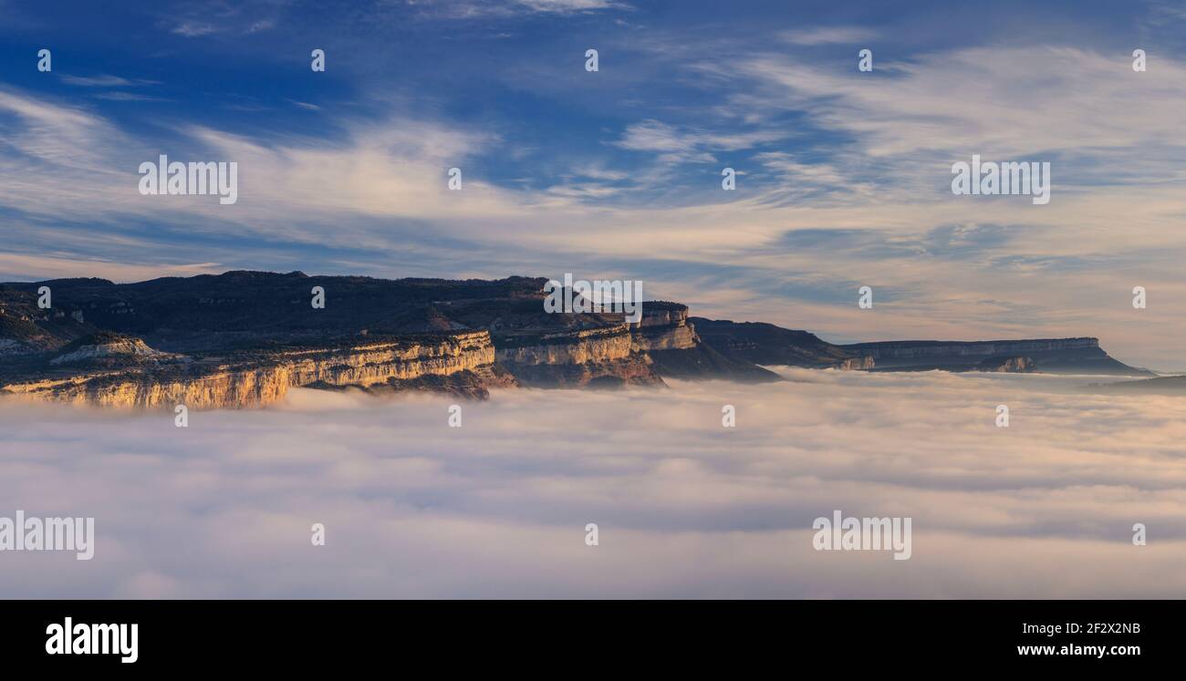 Sunrise with a sea of clouds over the Sau Reservoir. Panoramic view of the Tavartet Cliffs seen from Roca del Migdia summit (Collsacabra, Catalonia) Stock Photo