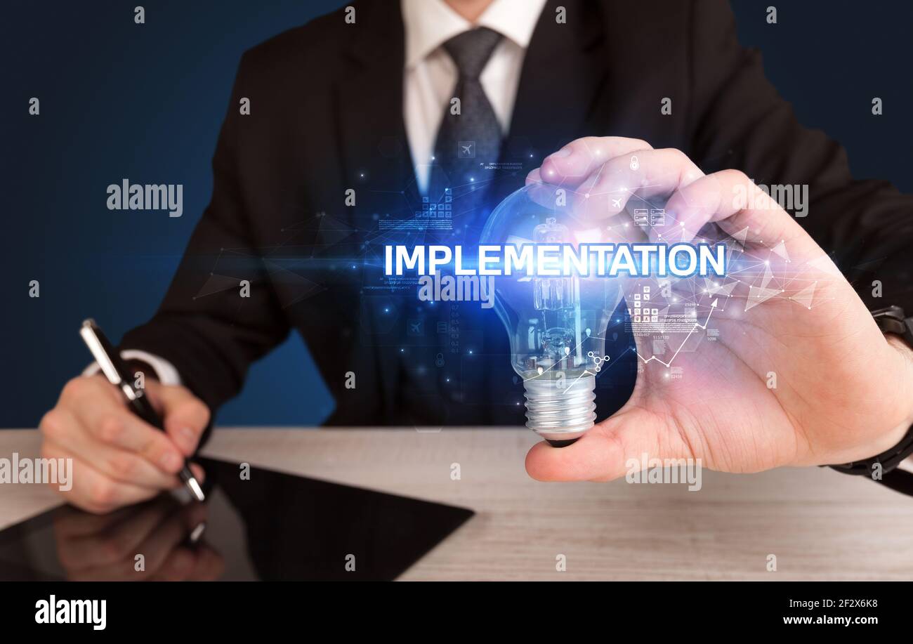Businessman holding a light bulb Stock Photo - Alamy