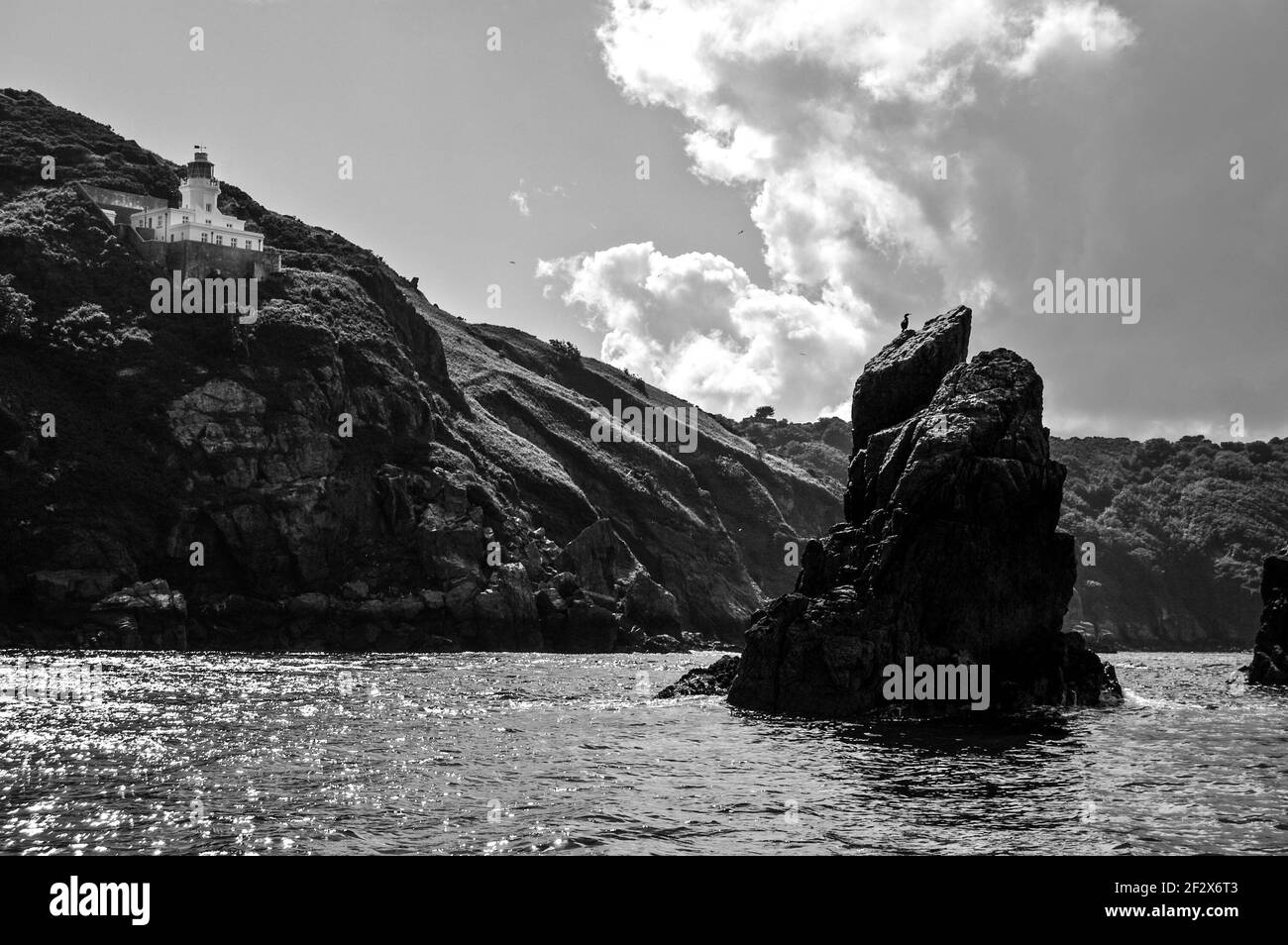 view of an old lighthouse on a rocky perch, Channel Islands, UK Stock Photo