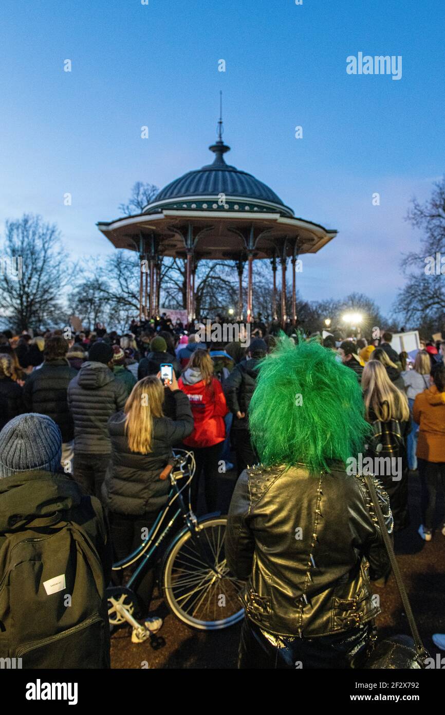 Hundreds of people gather on Clapham Common at the bandstand as a vigil for the murdered woman Sarah Everard - the vigil had been banned for lockdown Stock Photo
