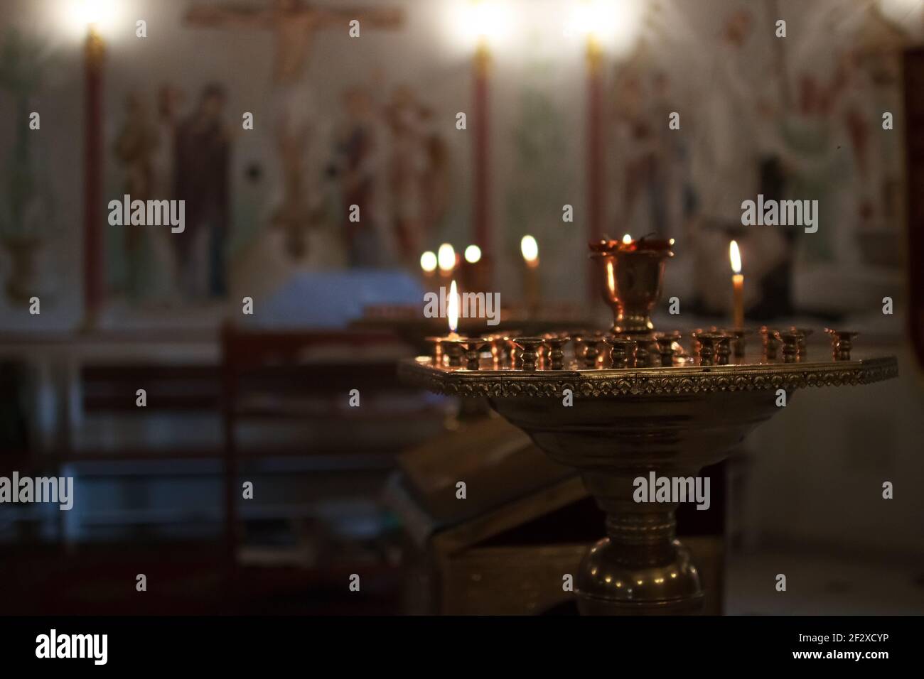 Church altar with alight candles candelabrum burning ritual Stock Photo