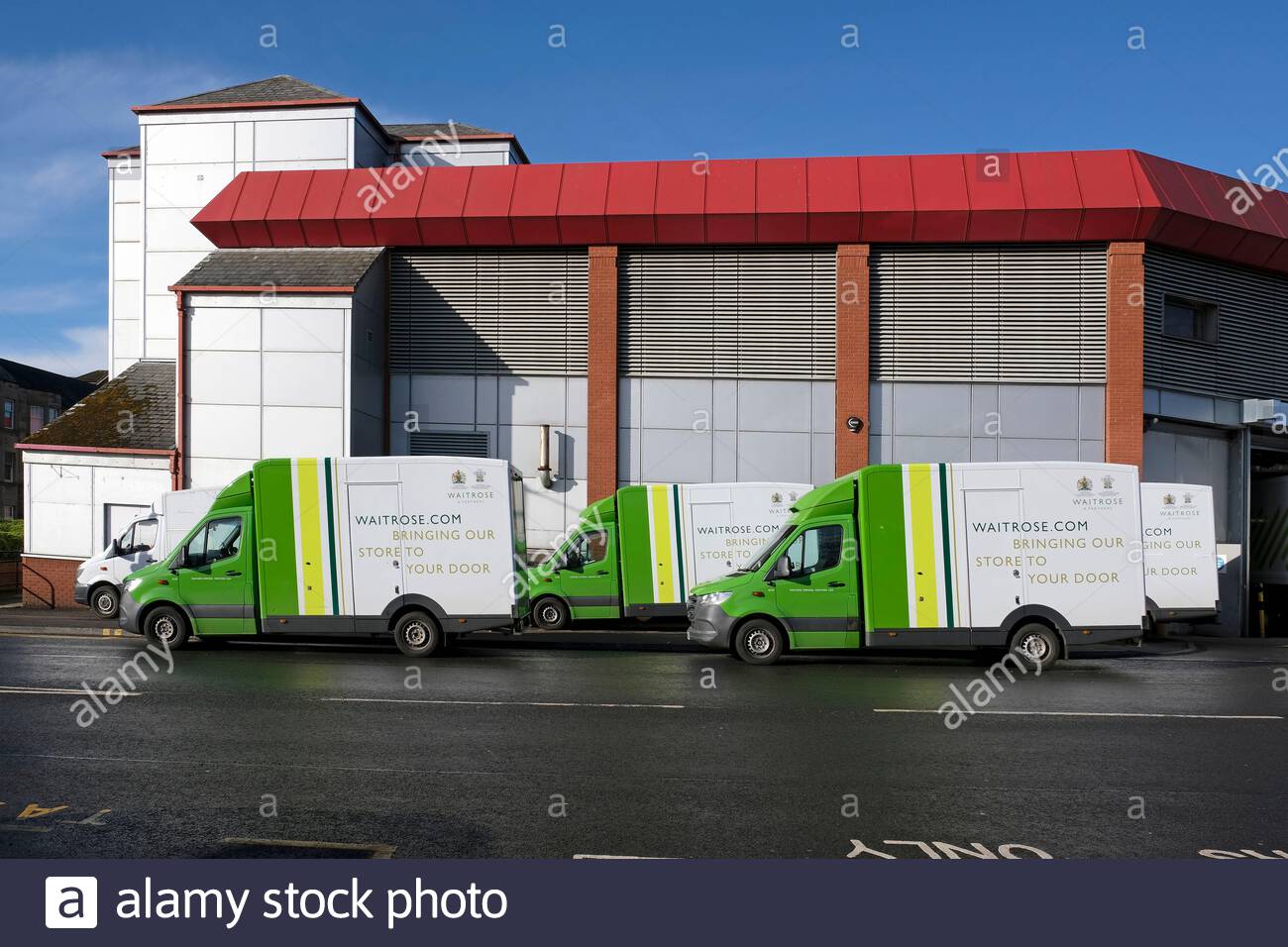 Waitrose Home Delivery vans queued up outside a Waitrose supermarket ready for deliveries Stock Photo