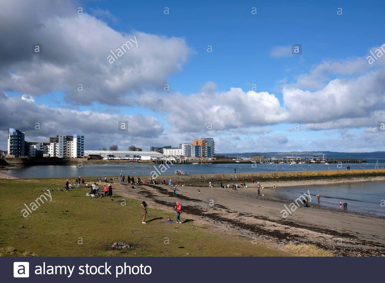 People enjoying Granton harbour breakwater and Wardie Bay on a sunny day, Edinburgh, Scotland Stock Photo