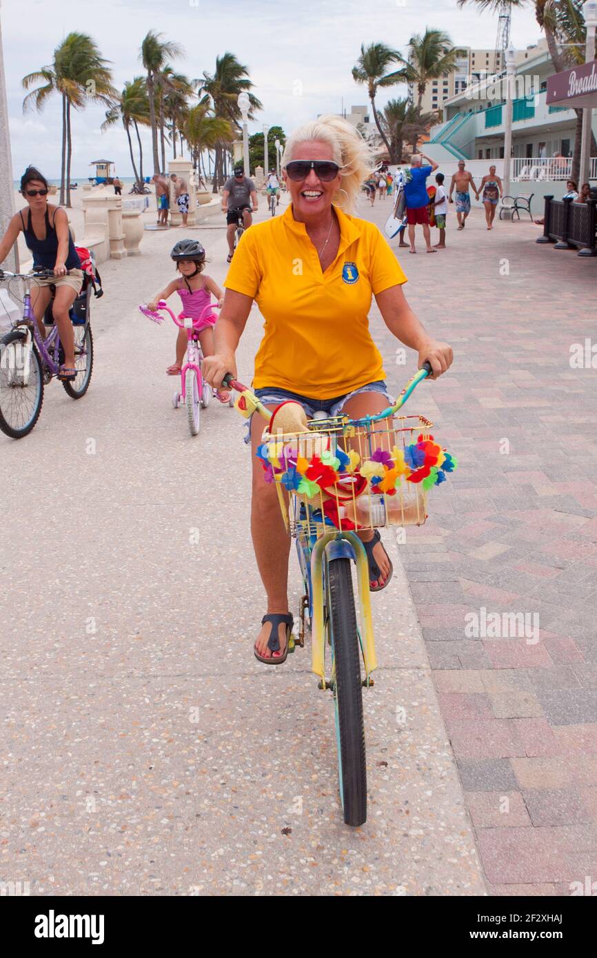 Hollywood Beach Broadwalk attracts people who like to bike, skate and jog on a sunny day. Stock Photo