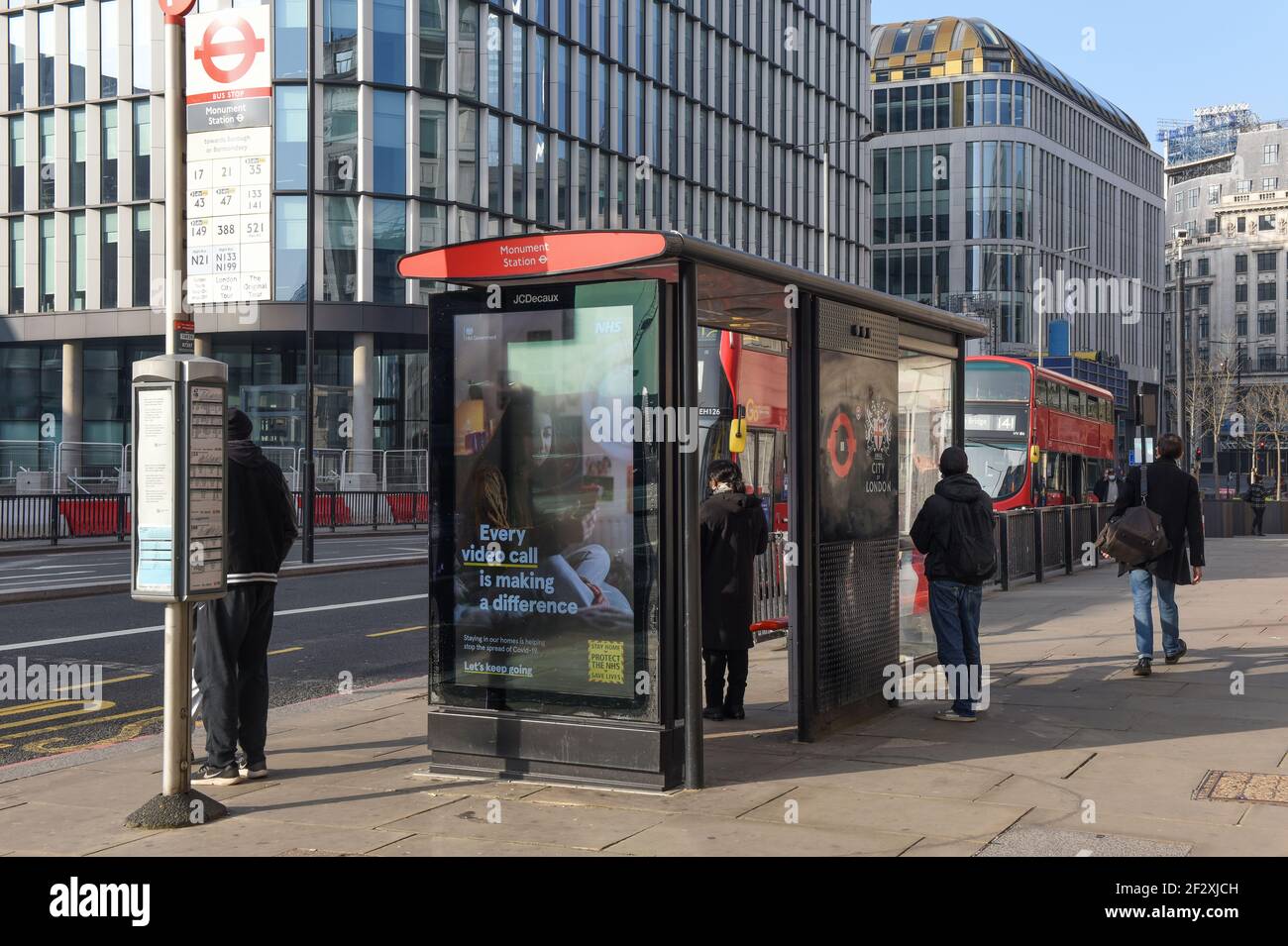 People waiting at the bus stop and advertisement about mental health and keeping safe, central London, Monument. Stock Photo