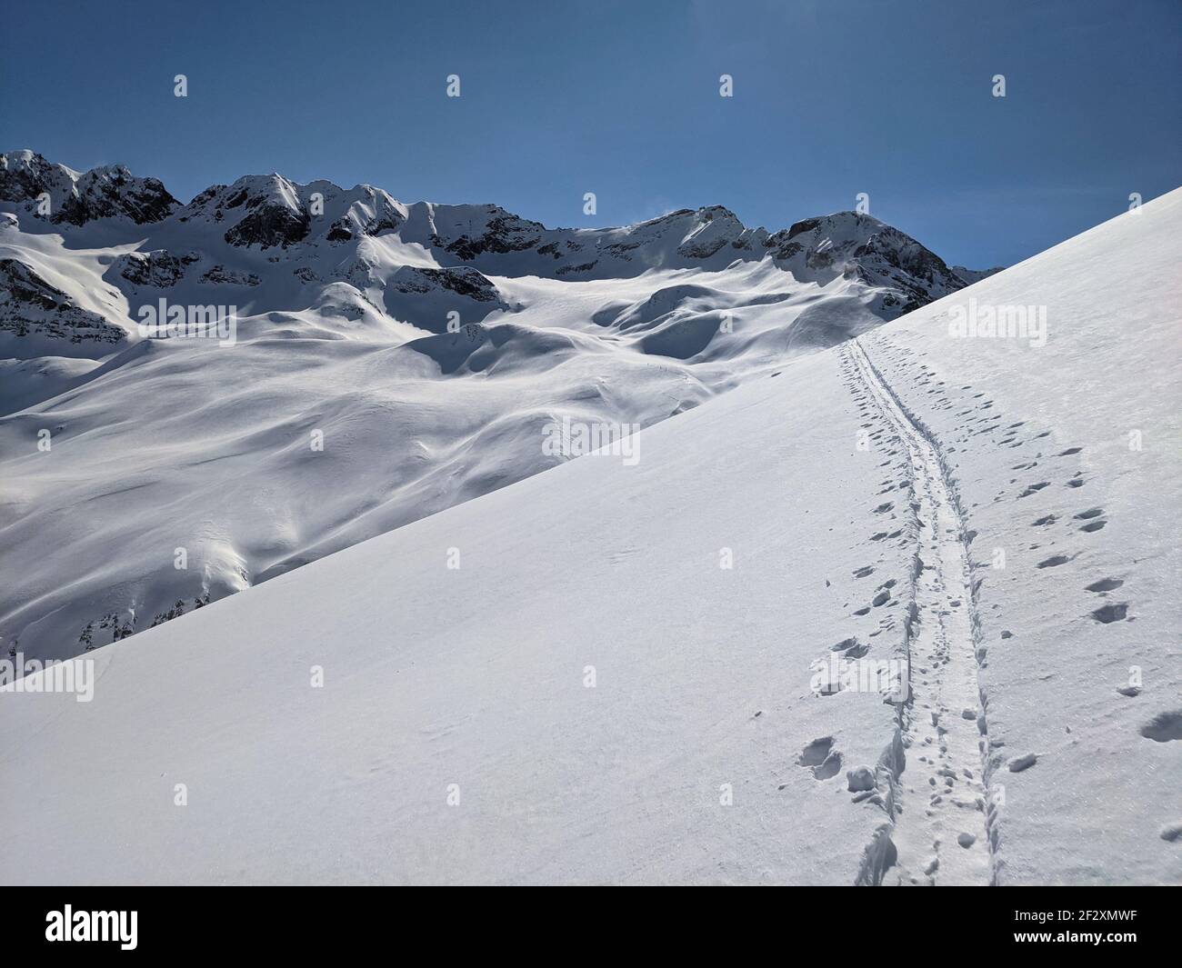 ski touring track in a grandiose winter landscape with high mountains. Mountaineering in the Ducan valley above Davos Stock Photo