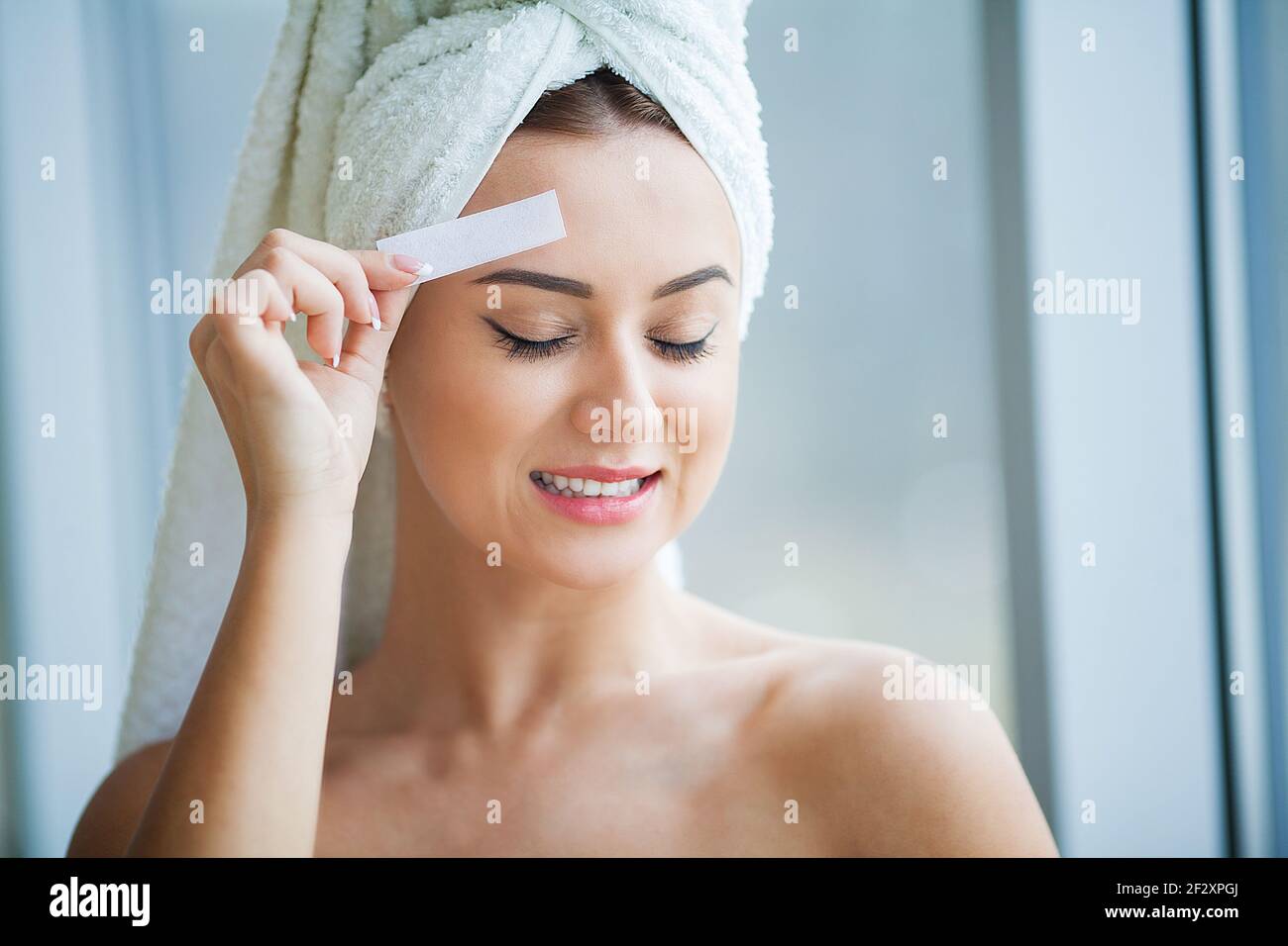 Beautician waxing young woman's eyebrows in spa center Stock Photo Alamy