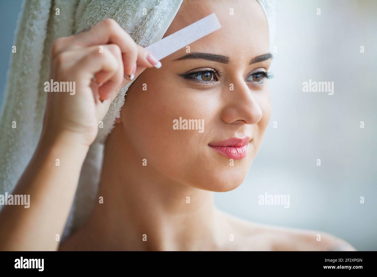 Beautician waxing young woman's eyebrows in spa center Stock Photo Alamy