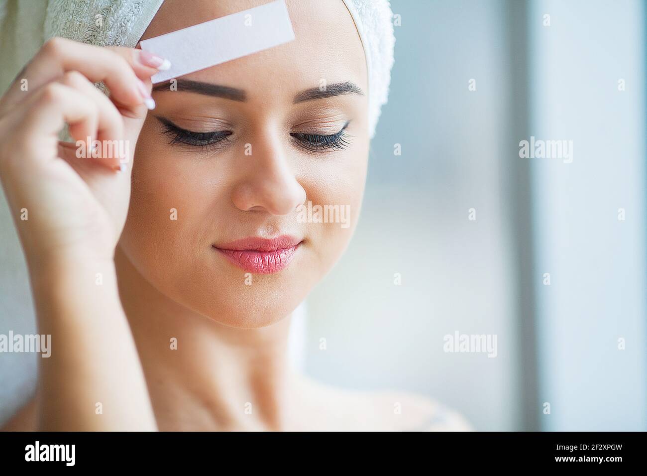 Beautician waxing young woman's eyebrows in spa center Stock Photo Alamy