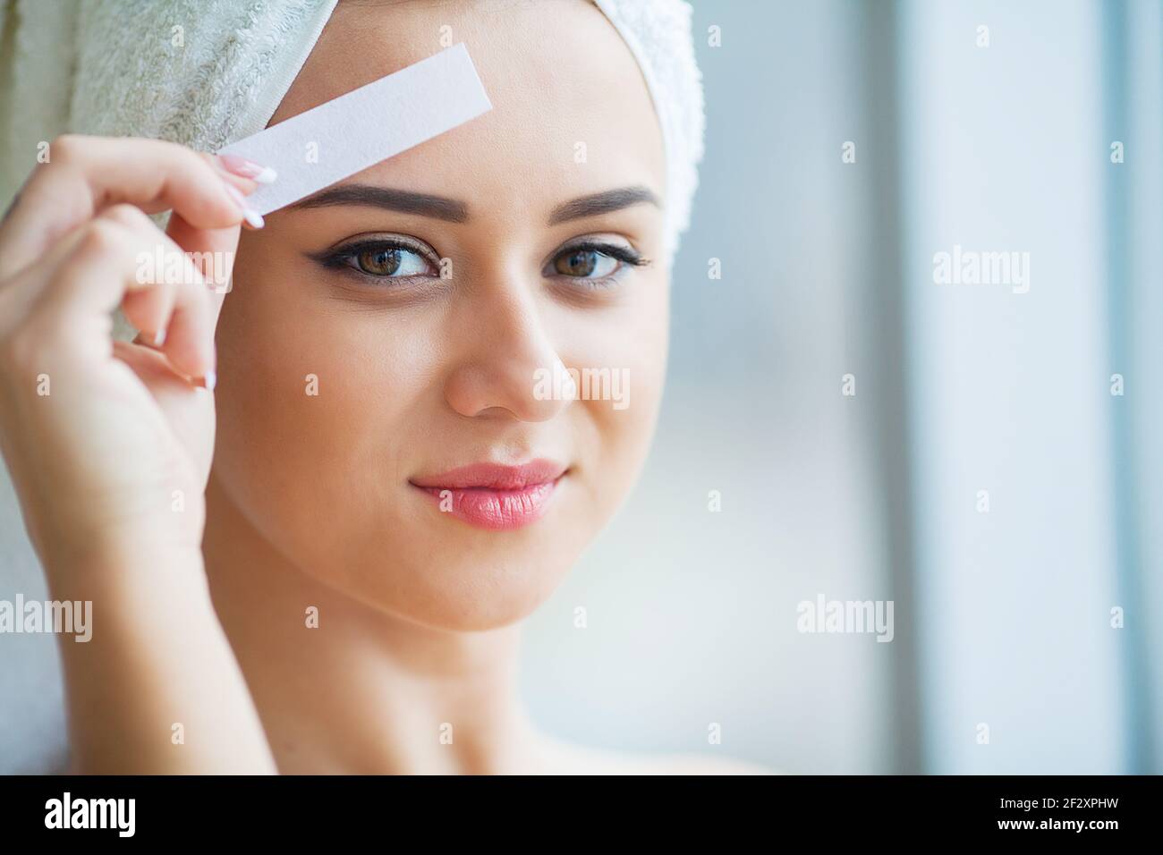 Beautician waxing young woman's eyebrows in spa center Stock Photo Alamy