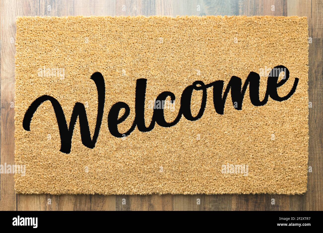 Tan Welcome Mat On Wood Floor Background.. Stock Photo