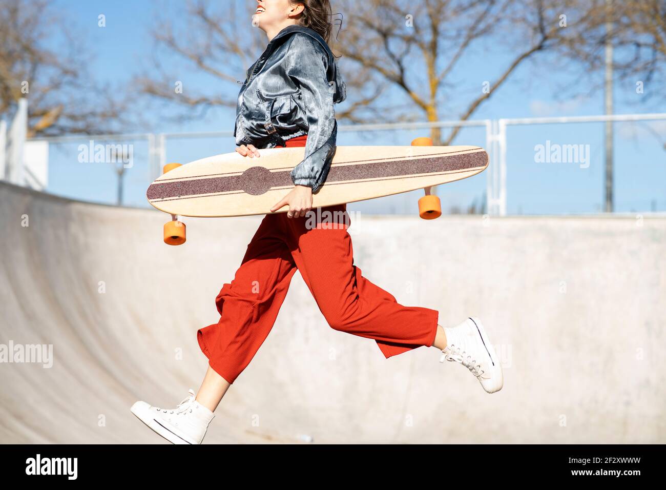 Side view of cropped unrecognizable happy young female in stylish
