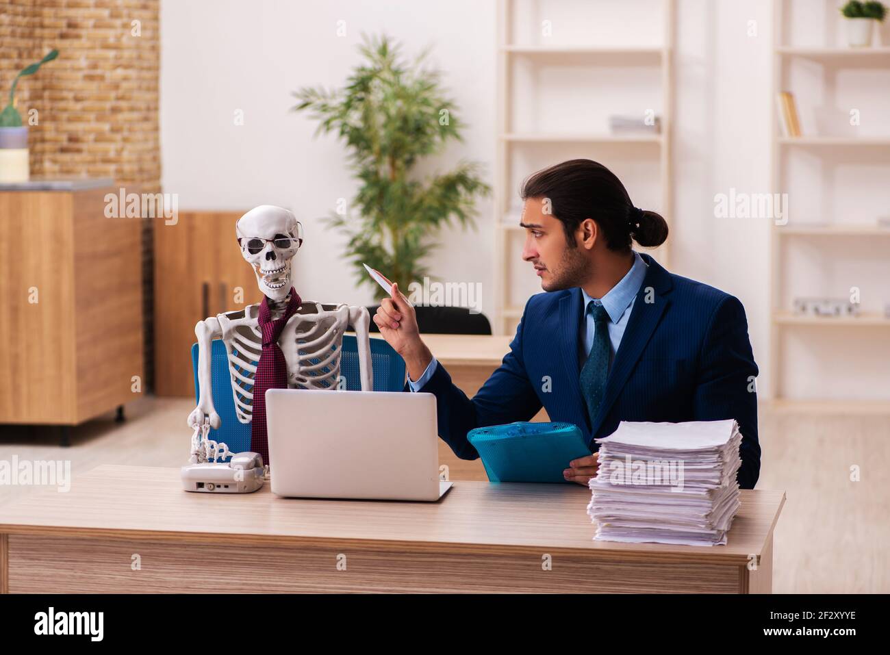 Dead employee working in the office in funny concept Stock Photo Alamy