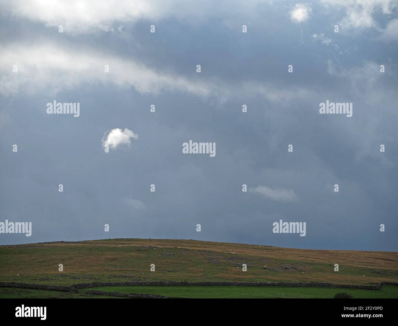 northern landscape with grey skies & broken sunshine above rolling hills and dry-stone walls in Eden Valley farmland, Cumbria, England, UK Stock Photo