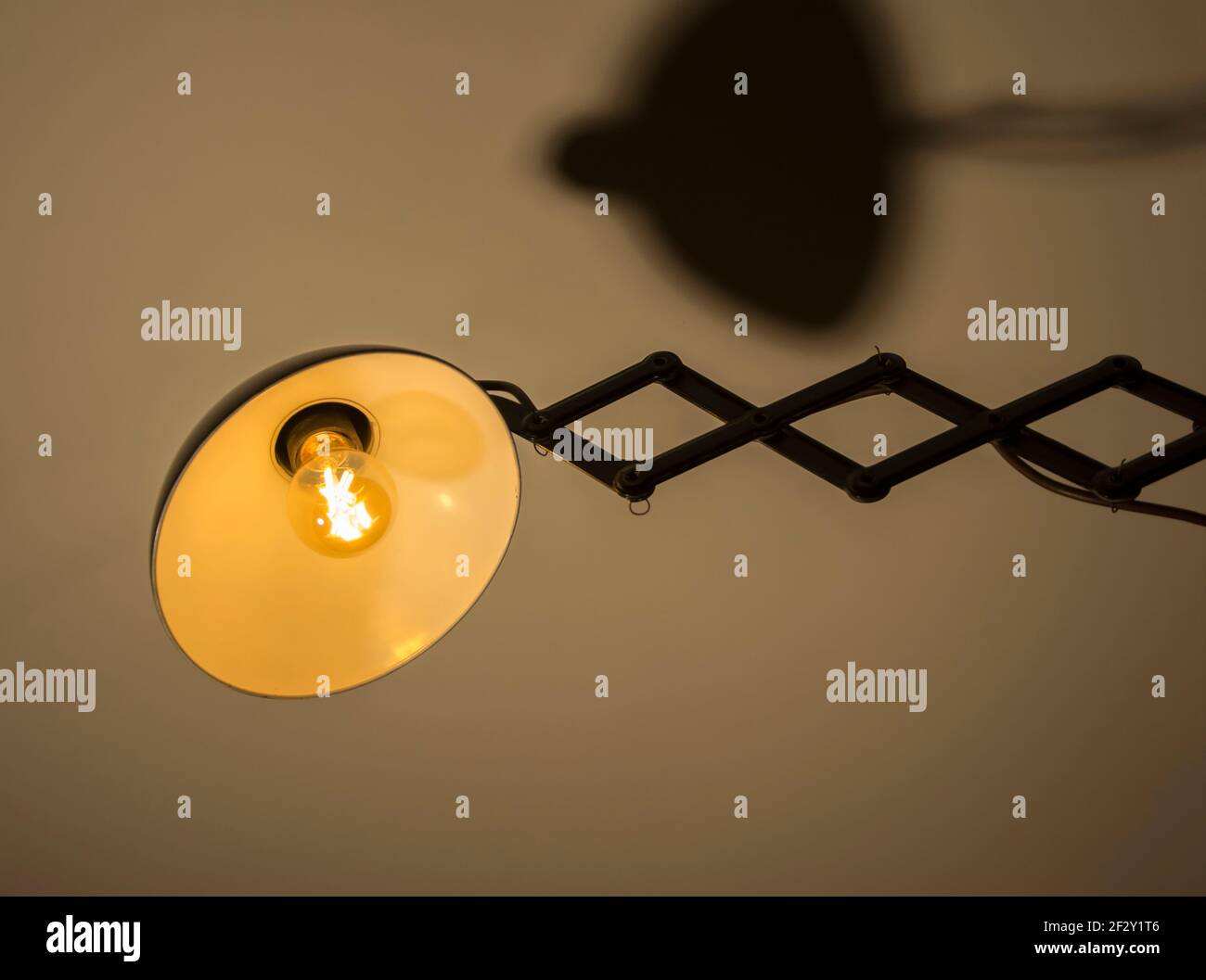 A 1930's Bauhaus scissor type lamp holder with a warm filament lamp