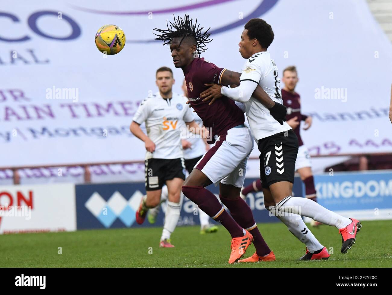 Tynecastle Park, Edinburgh, Scotland. UK .13th March 21. Scottish Championship Match .Hearts vs Ayr Utd Hearts' French striker, Armand Gnanduillet, challenged by Ayr Utd Corrie Ndaba Credit: eric mccowat/Alamy Live News Stock Photo