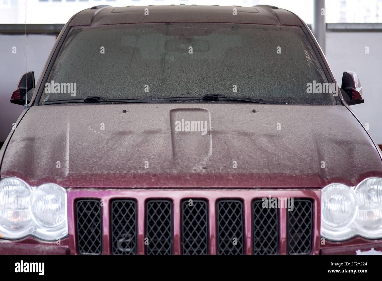 dirty red car windshield wipers covered with a layer of dust abandoned