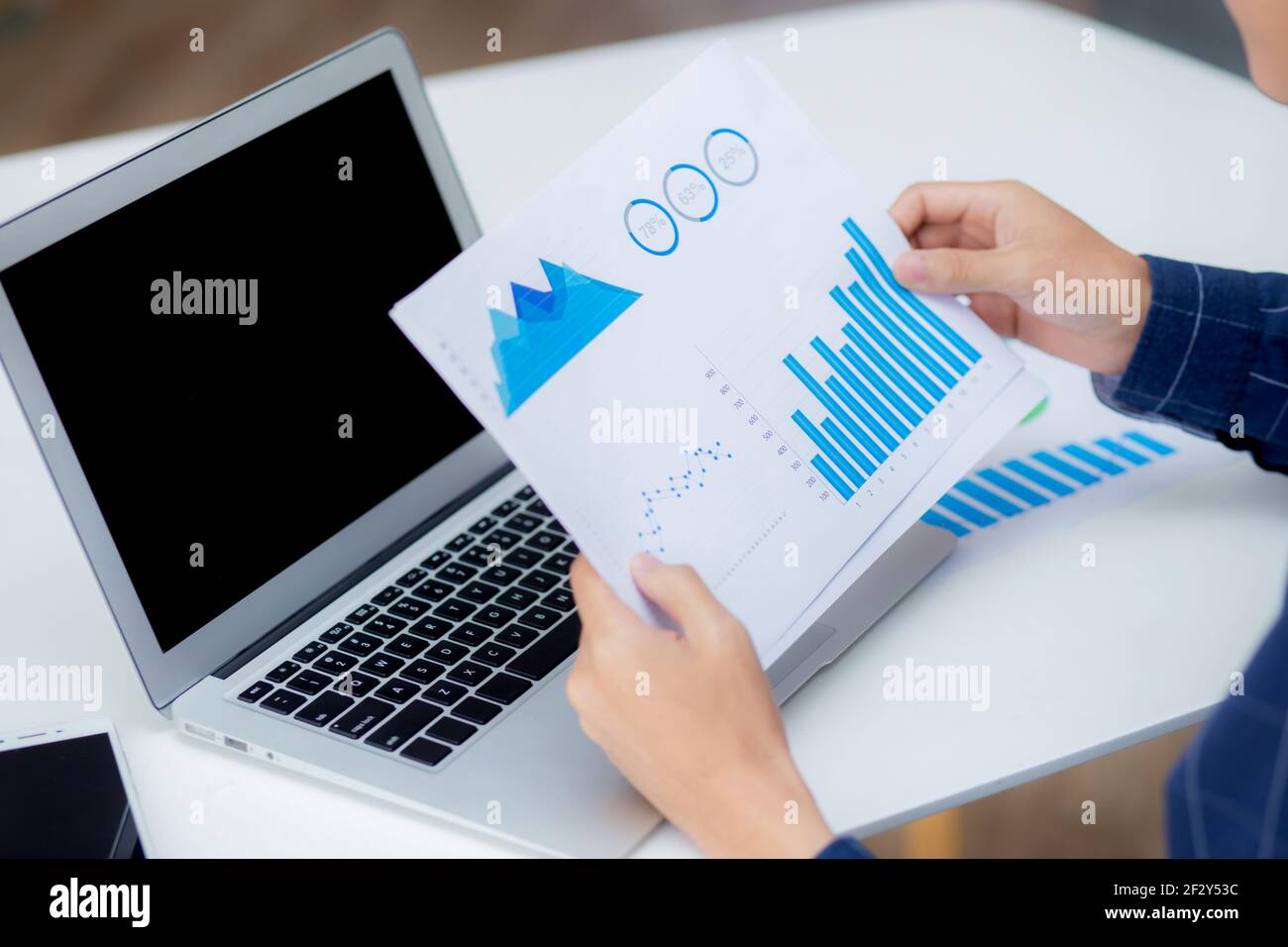Hand of young business man looking document data graph and chart paper Hand of young business man looking document data graph and chart paper