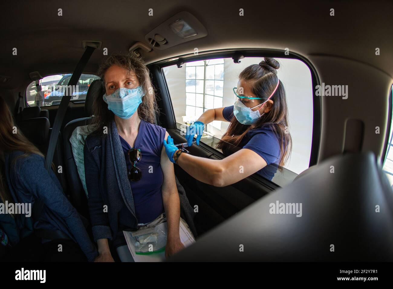A woman receives a Covid-19 shot at a Sutter Health drive through vaccination site in Santa Cruz, California.  March 2021 Stock Photo
