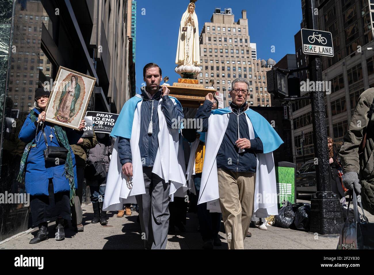 New York, United States. 13th Mar, 2021. Clergy and members of Roman Catholic Church The Holy Innocents march and pray to end abortion on Midtown streets. Mostly maskless people march and after that congregate inside the church to offer prayer. Clergy were carrying the statue of Madonna, while parishioners were holding posters. (Photo by Lev Radin/Pacific Press) Credit: Pacific Press Media Production Corp./Alamy Live News Stock Photo