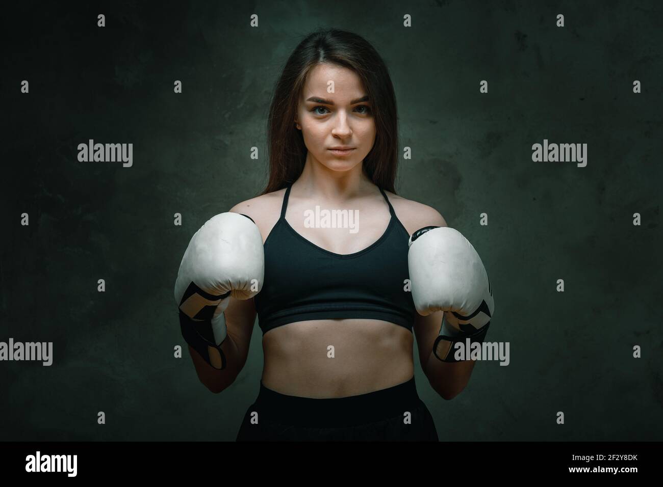 Young angry fighter girl with white gloves fighting practice throwing  aggressive punch training shadow boxing workout on black dirty grunge  backgrou Stock Photo - Alamy