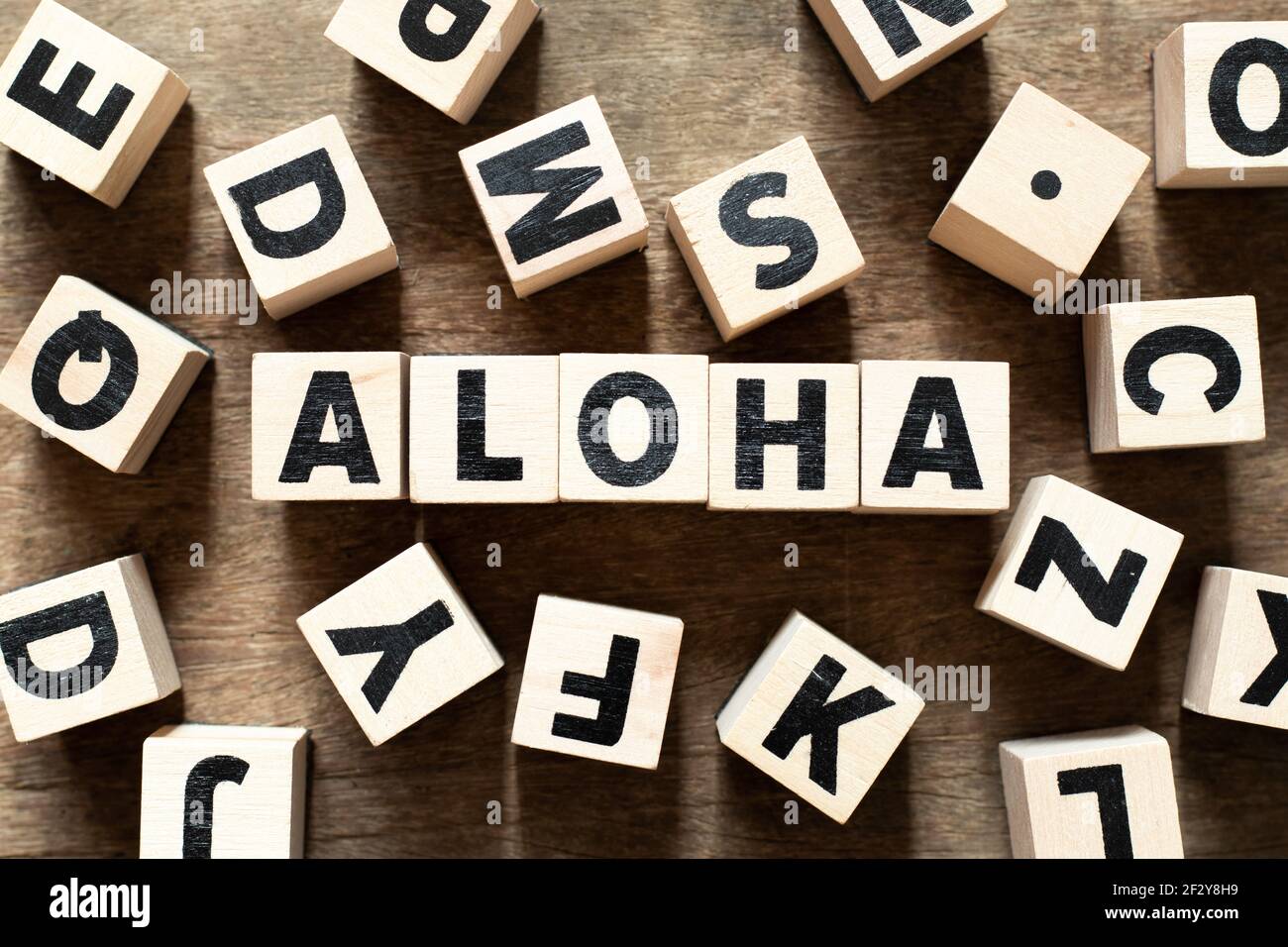 Wood letter block in word aloha on wood background with another ...