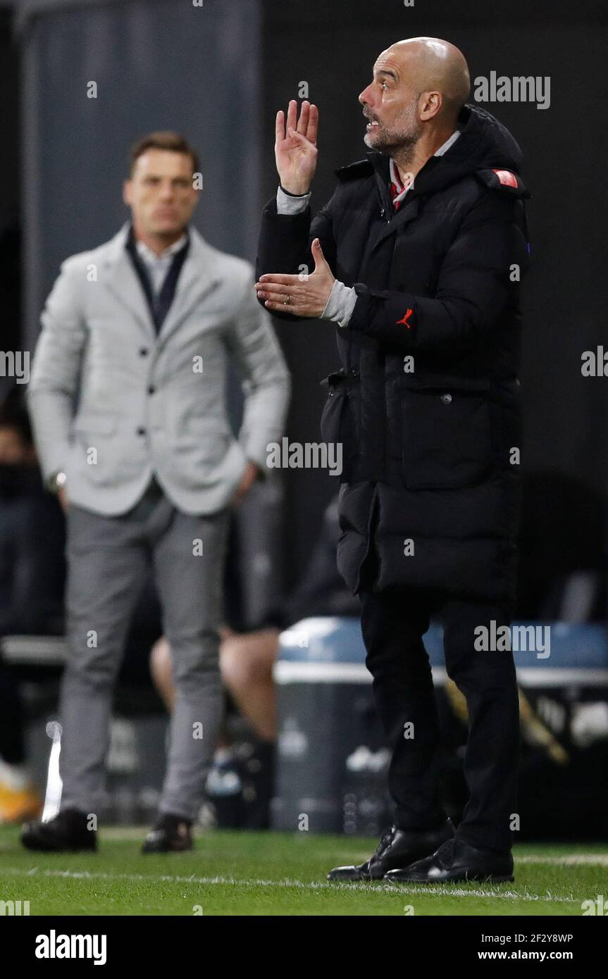 London, UK. 13th Mar, 2021. Manchester Citys manager Josep Guardiola (R) reacts during the English Premier League match between Fulham and Manchester City at Craven Cottage in London, Britain on March 13, 2021. Credit: Han Yan/Xinhua/Alamy Live News Stock Photo