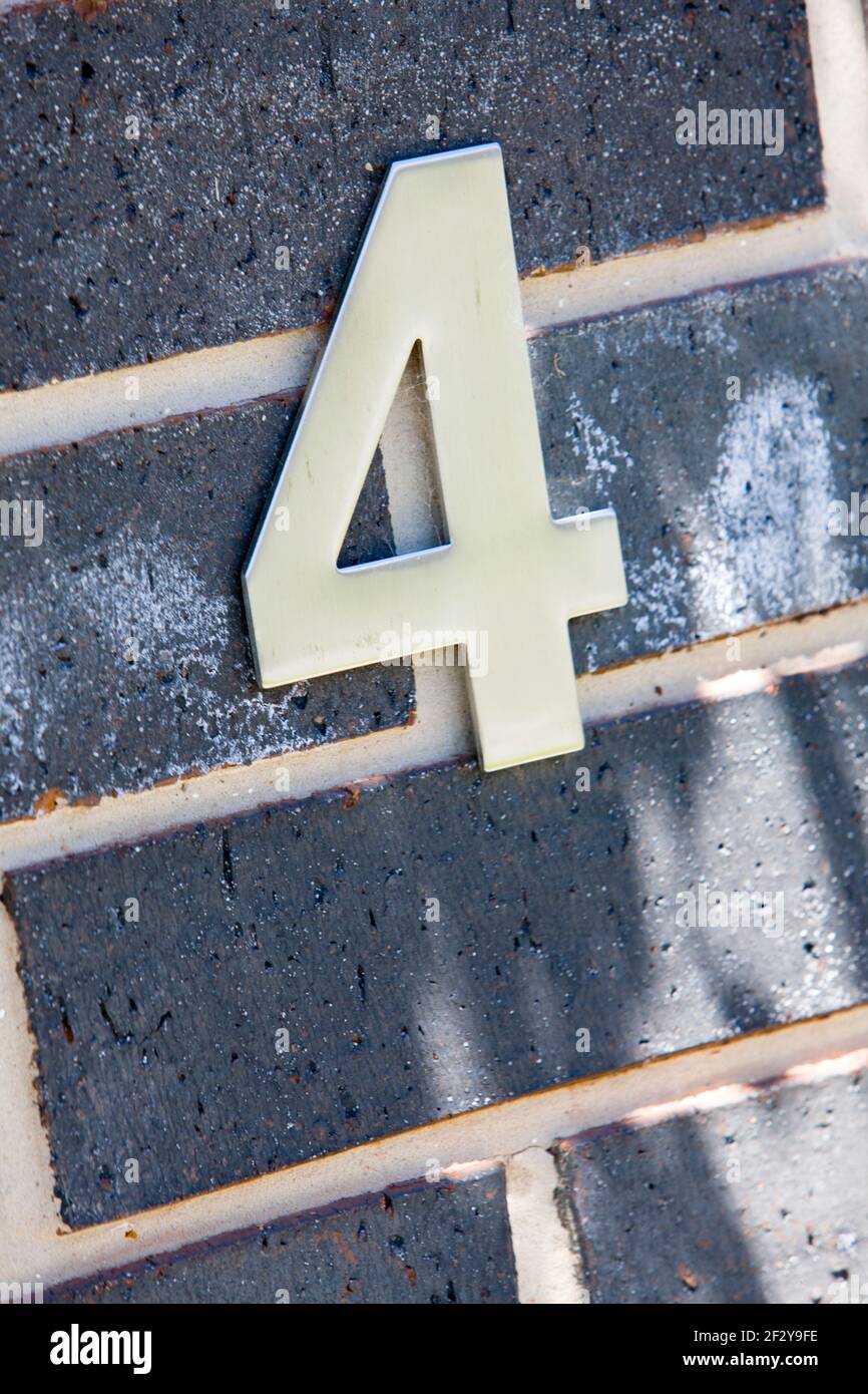 Close-up of metallic 4 on grey brick wall Stock Photo