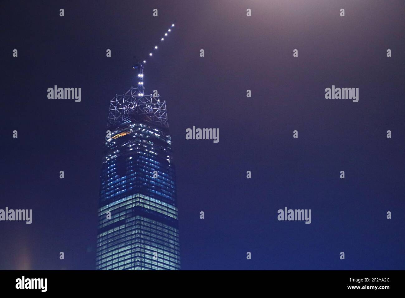 The Exchange 106' Under Construction At Night An almost completed skyscraper with a crane on top and with only the glass crown left to construct: Stock Photo