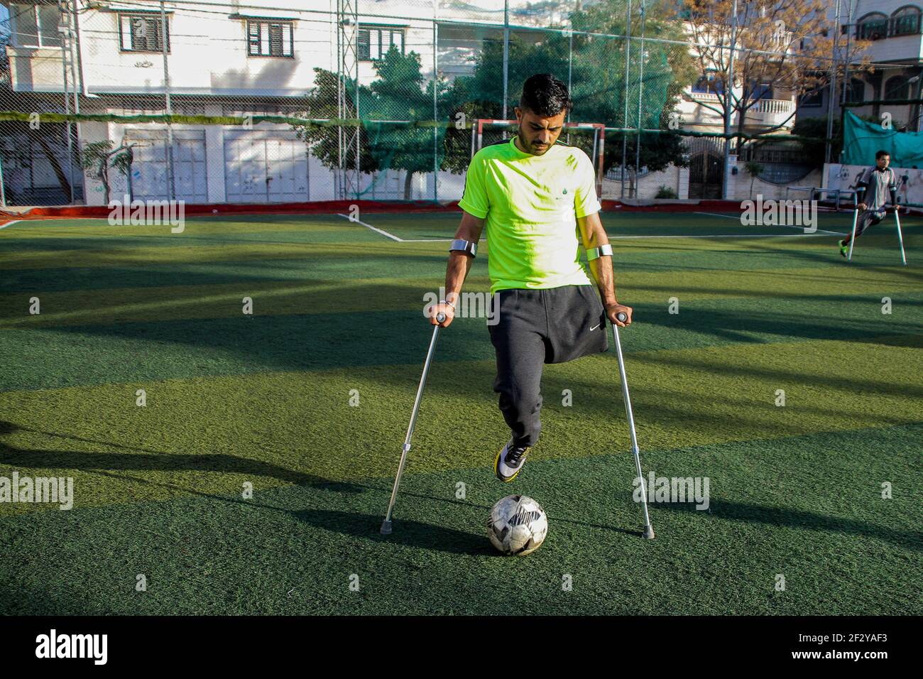 March 13, 2021: Gaza, Palestine. 13 March 2021. Palestinians with crutches play football in the Al-Jazeera Club in Gaza City on the 'Palestinian Day of the injured''. The players have lost a leg either in Israeli attacks on Gaza or in the March of Return demonstrations, during which they were shot to their limbs by Israeli soldiers based at the perimeter fence with Gaza. Some of the severe limb gunshot wounds have required complex limb reconstruction treatments, while others have required amputation. Yet, despite losing a leg, many Palestinians have not lost their resilience and determinati Stock Photo