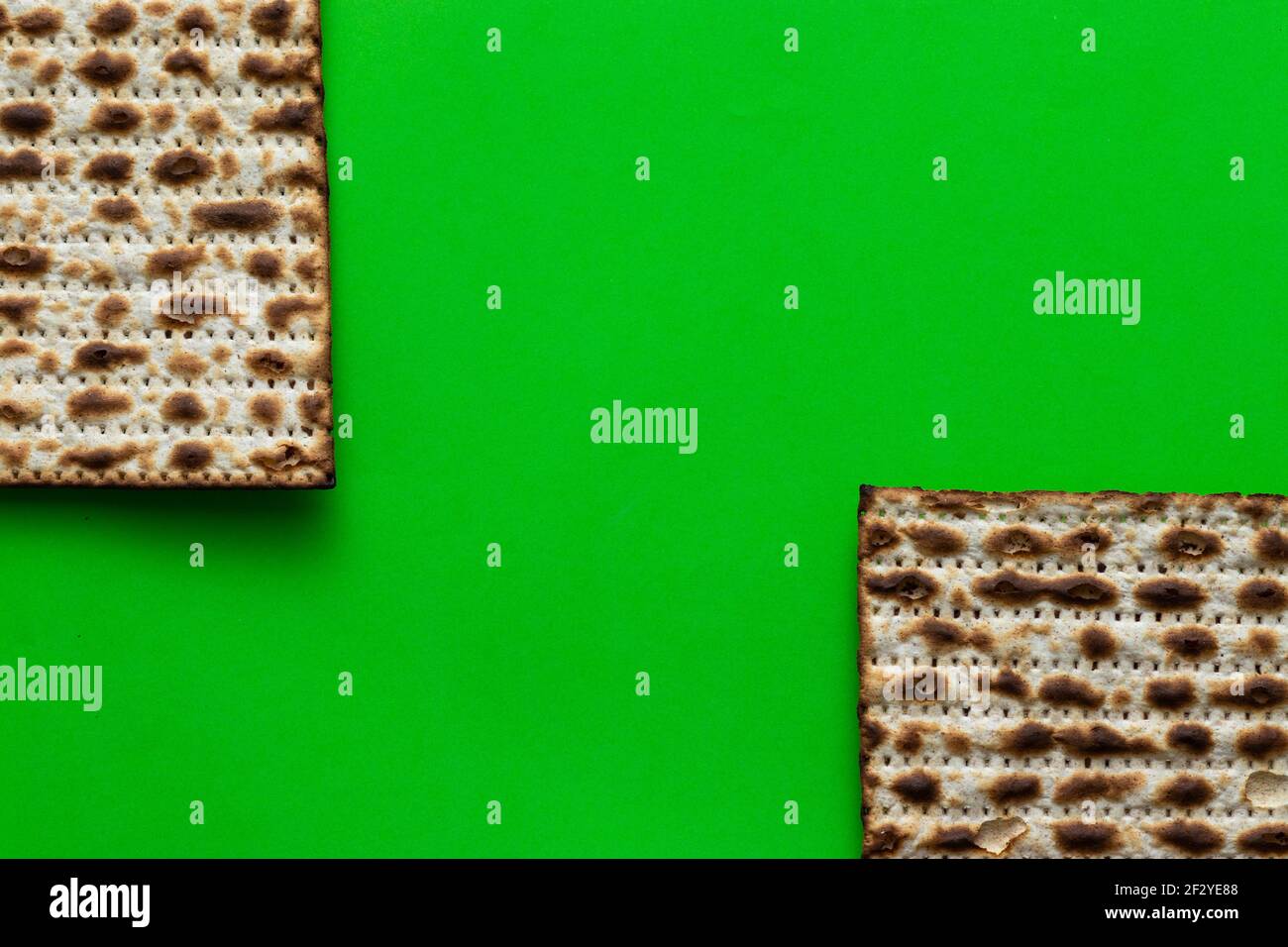 A close-up of two matzahs - bread for the Jewish Passover, on a green background Stock Photo