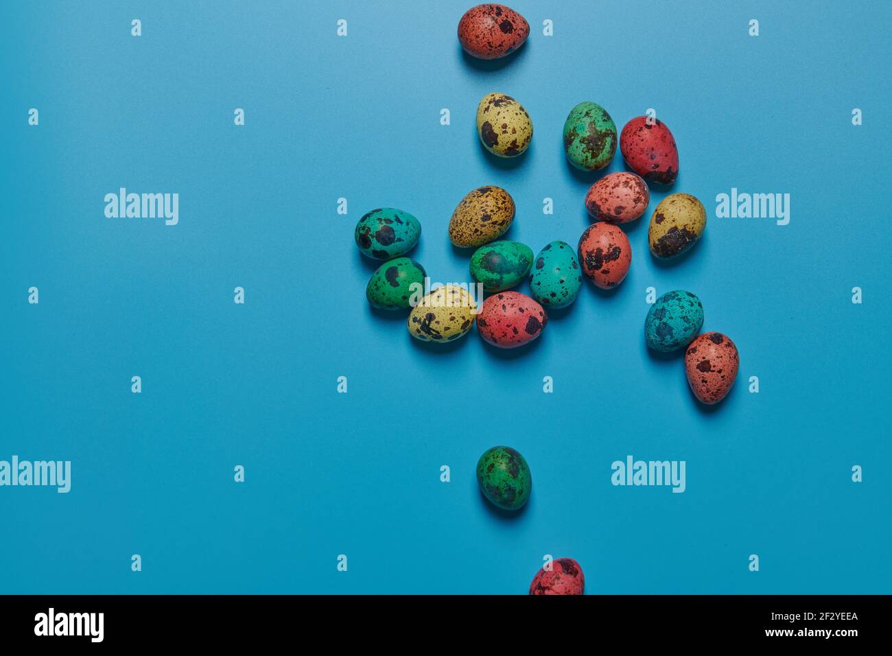 colored painted eggs scattered on a blue background for easter Stock Photo