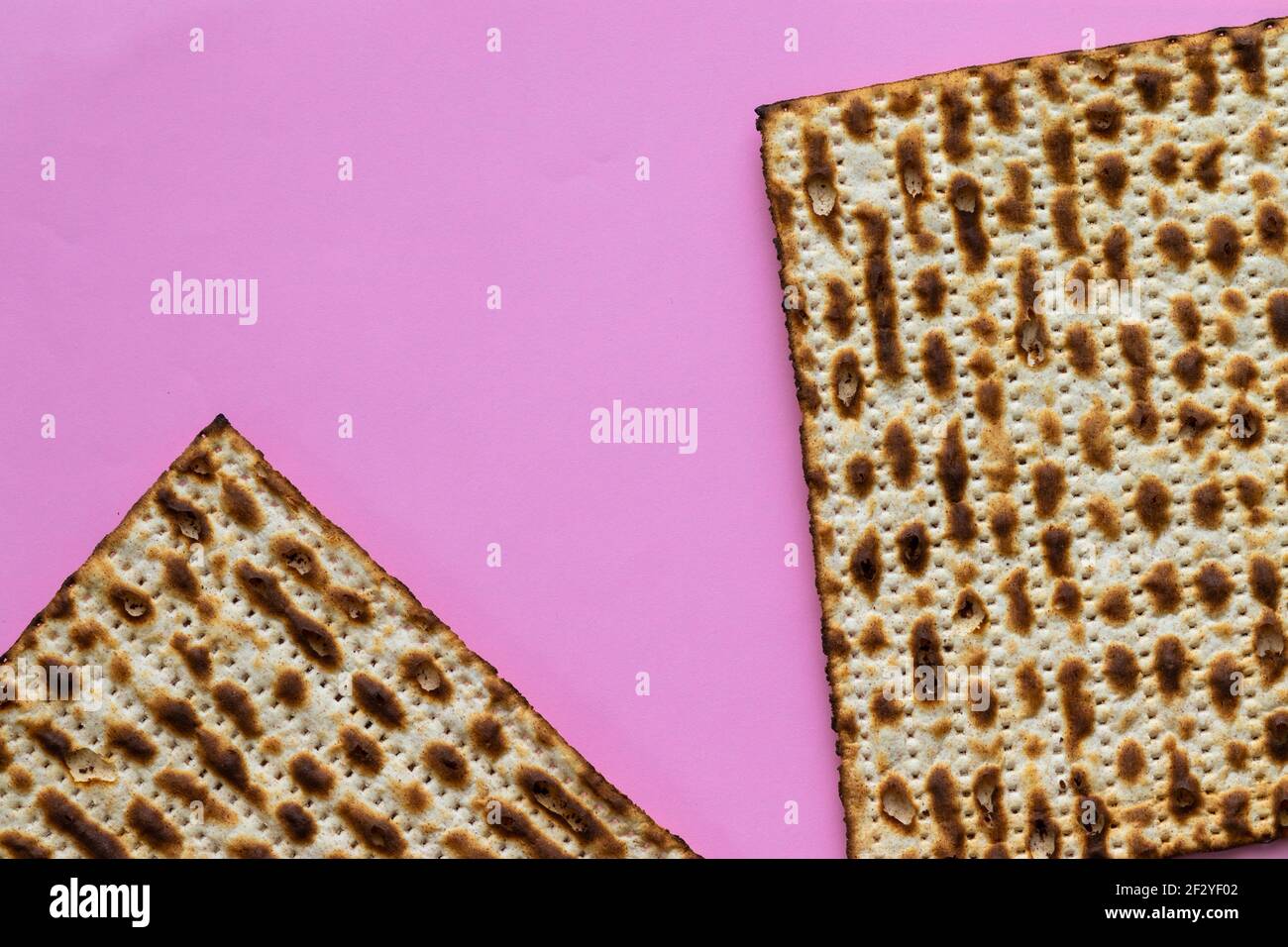 A close-up of two matzahs - bread for the Jewish Passover, on a pink background Stock Photo
