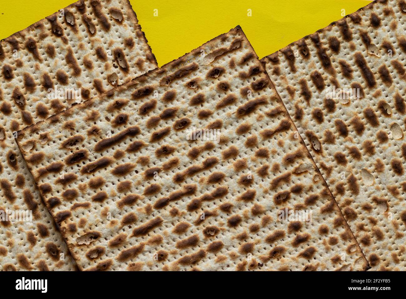 A close-up of three matzahs - bread for the Jewish Passover, on a yellow background Stock Photo