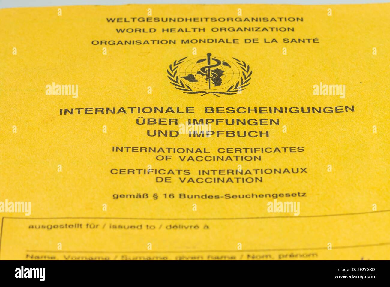 Cover sheet from the World Health Organization international vaccination card. Yellow vaccination card for vaccination against coronavirus and other Stock Photo