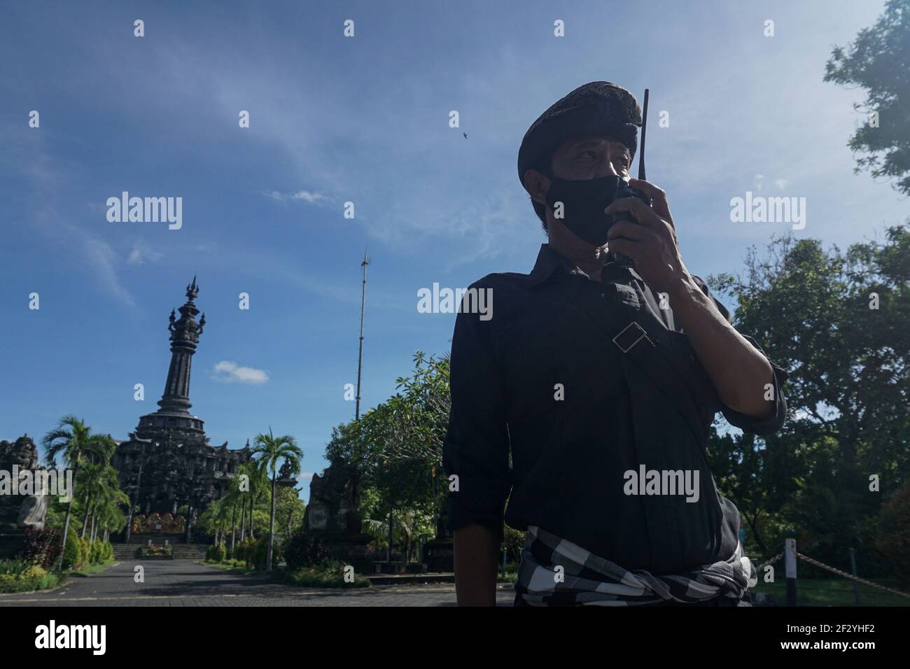 Bali, Indonesia. 14th Mar, 2021. A security official stands guard on street during the Nyepi Day, or the Day of Silence, amid the COVID-19 outbreak at Denpasar, Bali, Indonesia, March 14, 2021. Nyepi marks the New Year day of the Balinese Saka calendar in Indonesia. On this public holiday, locals devote themselves to fasting and meditation, while refraining from practices such as lighting fires, working, traveling and entertaining. Credit: Bisinglasi/Xinhua/Alamy Live News Stock Photo
