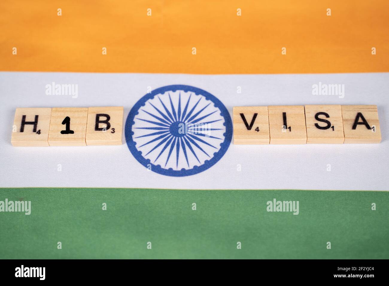 Maski, India 11,March 2021 : selective focus on wooden letters, H1b Visa scribble tiles on Indian flag concept of H1b Visa for Indians Stock Photo