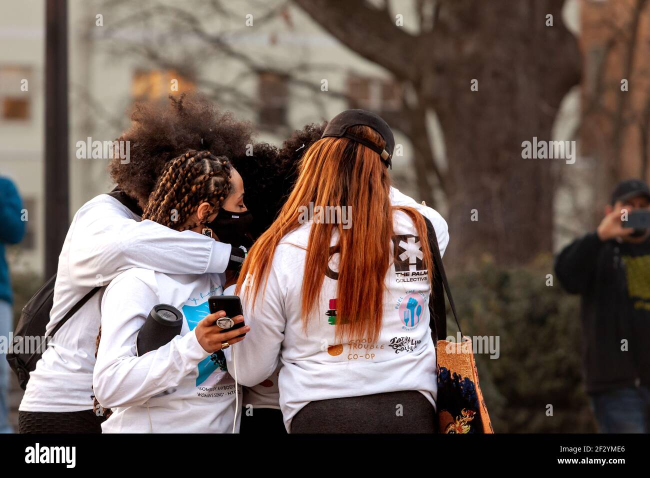 Washington, DC, USA, 13 March, 2021.  Pictured:  Organizers of a candlelight vigil for Breonna Taylor share a group hug.  The vigil marked the one year anniversary of Taylor's killing by Louisville Police officers, and called for them to be held accountable for her death.  Credit: Allison C Bailey/Alamy Live News Stock Photo