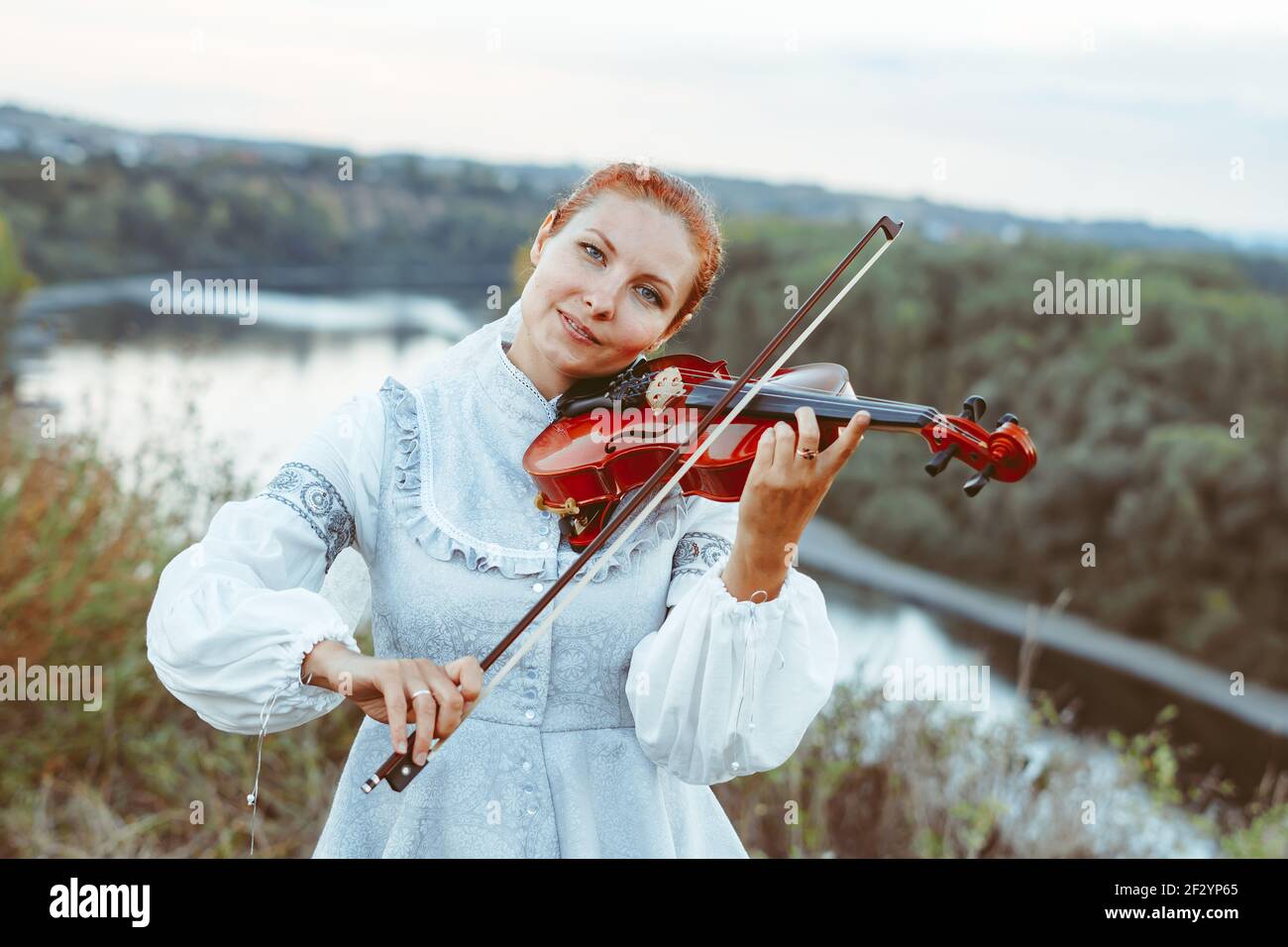 beautiful girl playing violin in white dress in forest Stock Photo - Alamy
