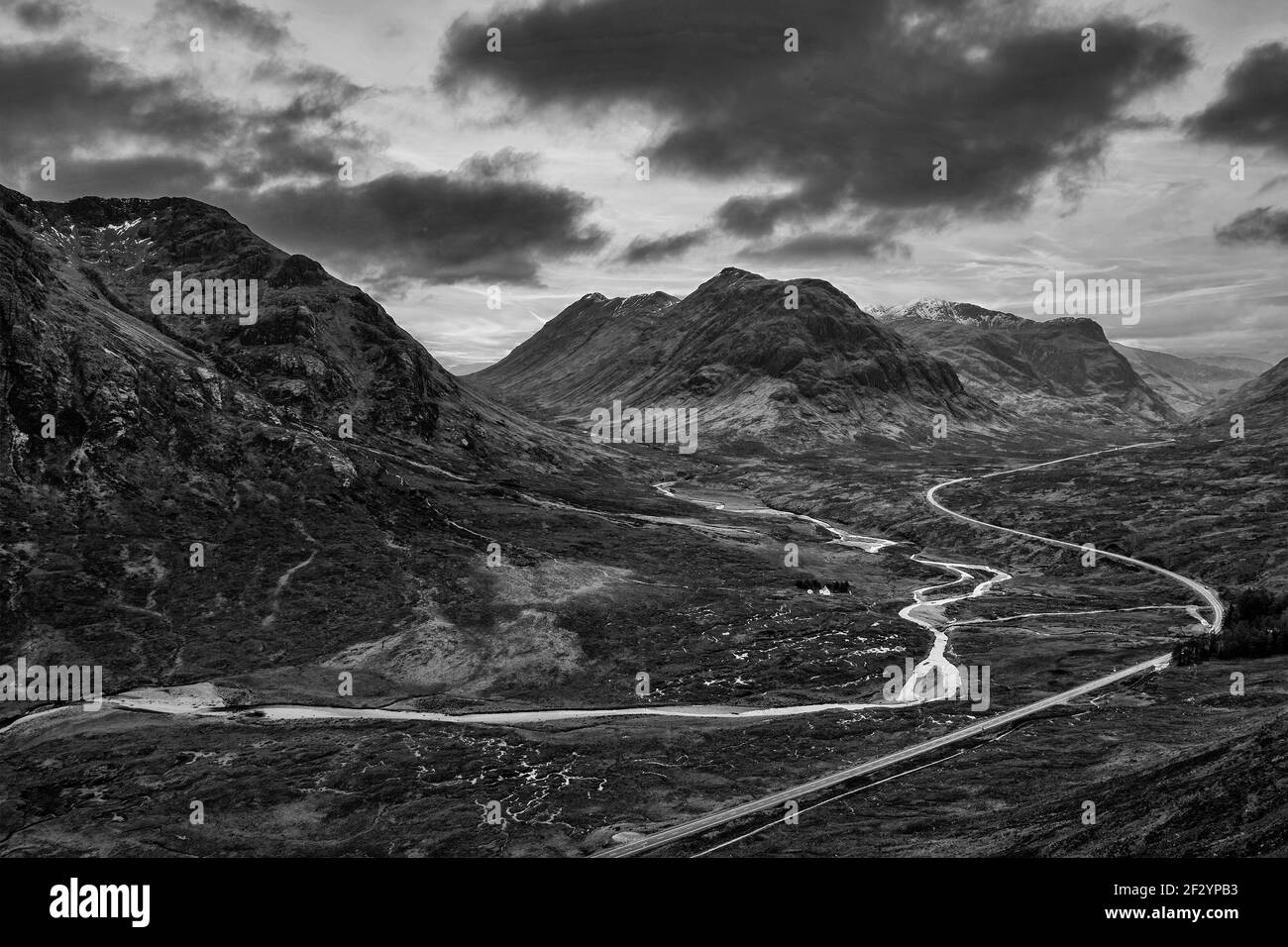 Flying drone dramatic  black and white landscape image of Buachaille Etive Mor and surrounding mountains and valleys in Scottish Highlands on a Winter Stock Photo