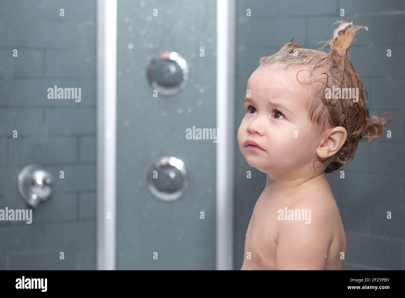 Child bathing. Funny baby kid bathed in foam and washing in bathtub at