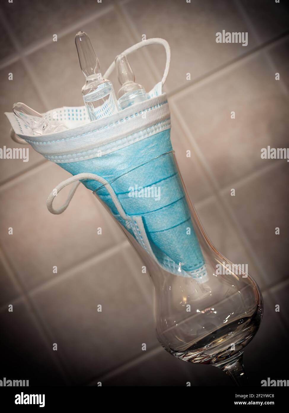 Medical mask and three ampoules in a glass. Stock Photo