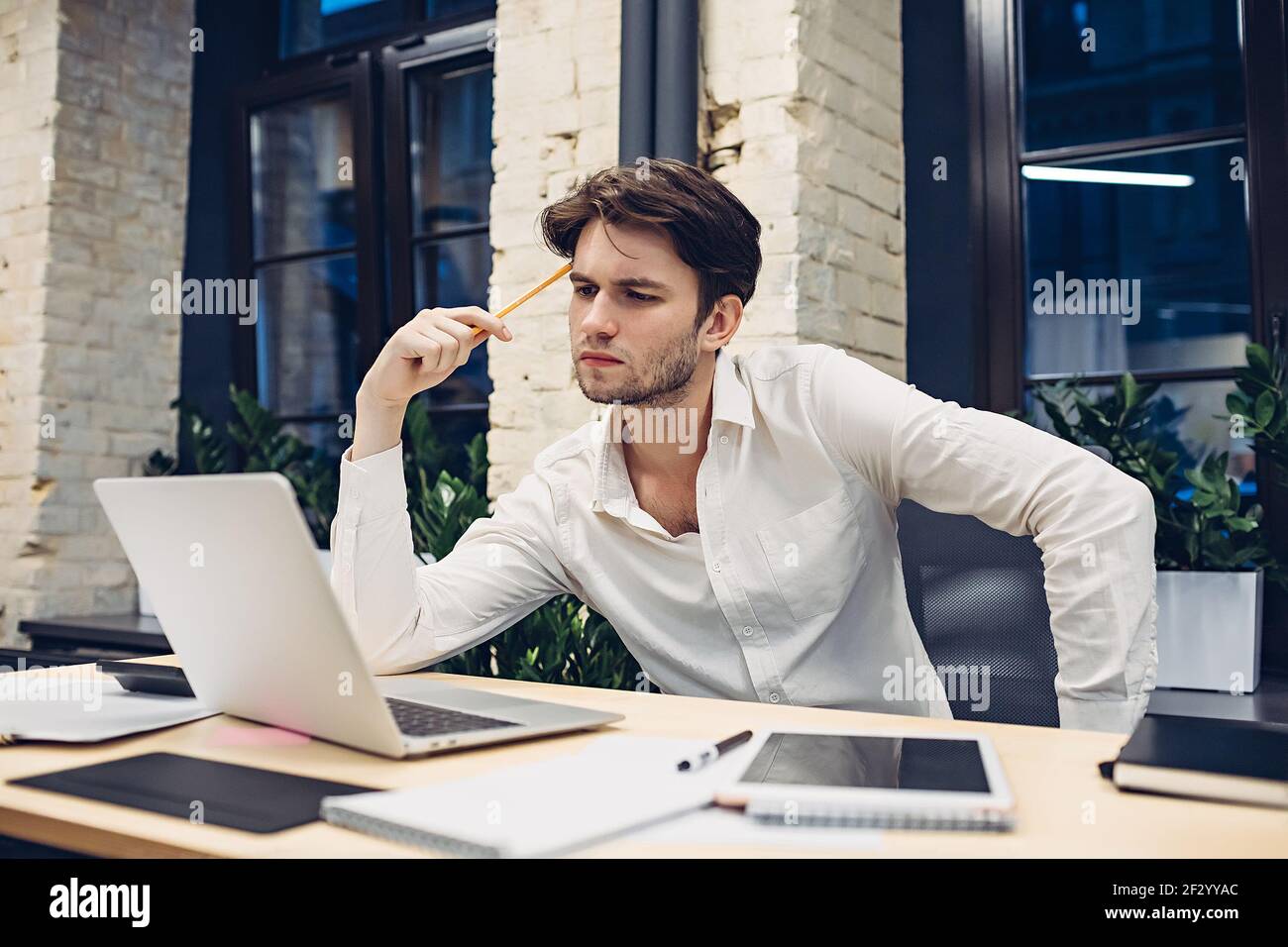 Focused businessman working on laptop in office Stock Photo