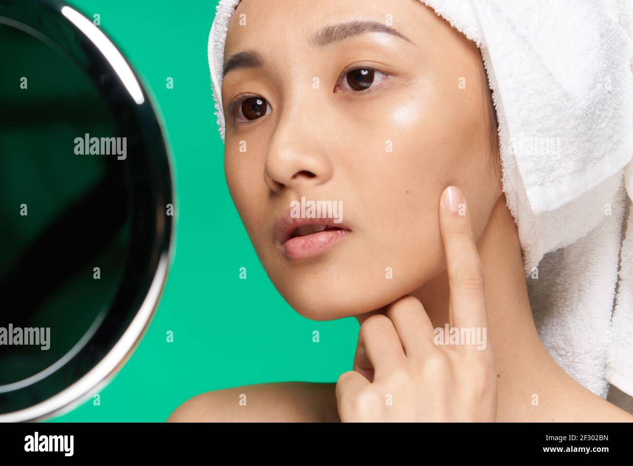 Pretty Asian Woman Looking In The Mirror And Touching Her Face Close Up