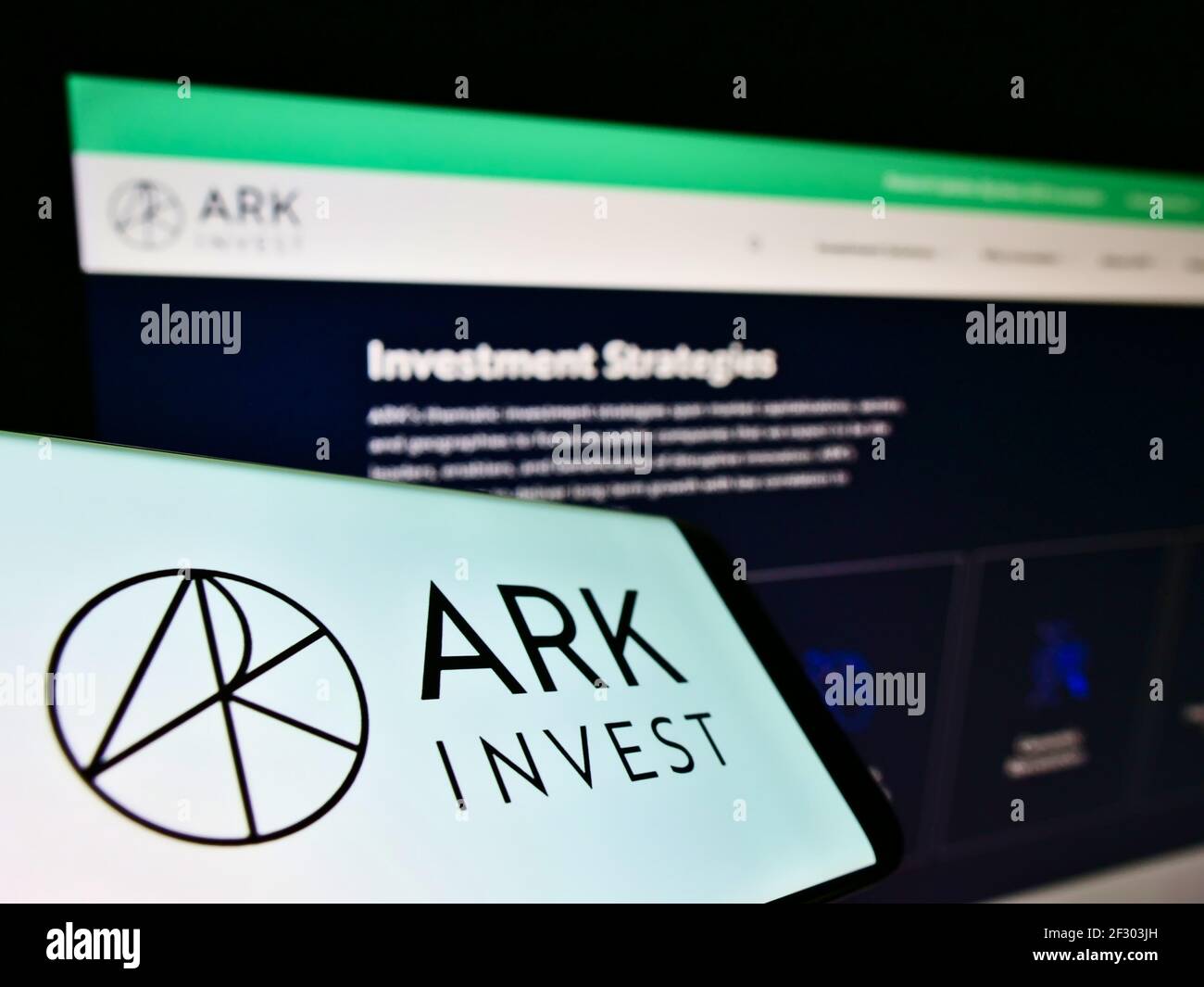 Smartphone with business logo of US asset manager ARK Investment Management on screen in front of website. Focus on center-right of phone display. Stock Photo