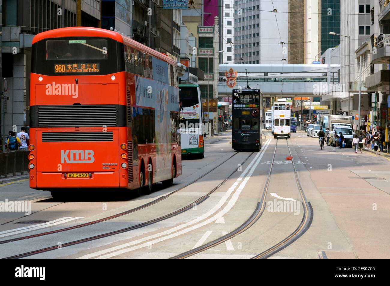 Kowloon Motor Bus (KMB) Volvo B8L red double-decker bus on Des Voeux Road Central (west of Pedder St.), Hong Kong with tram in the background Stock Photo
