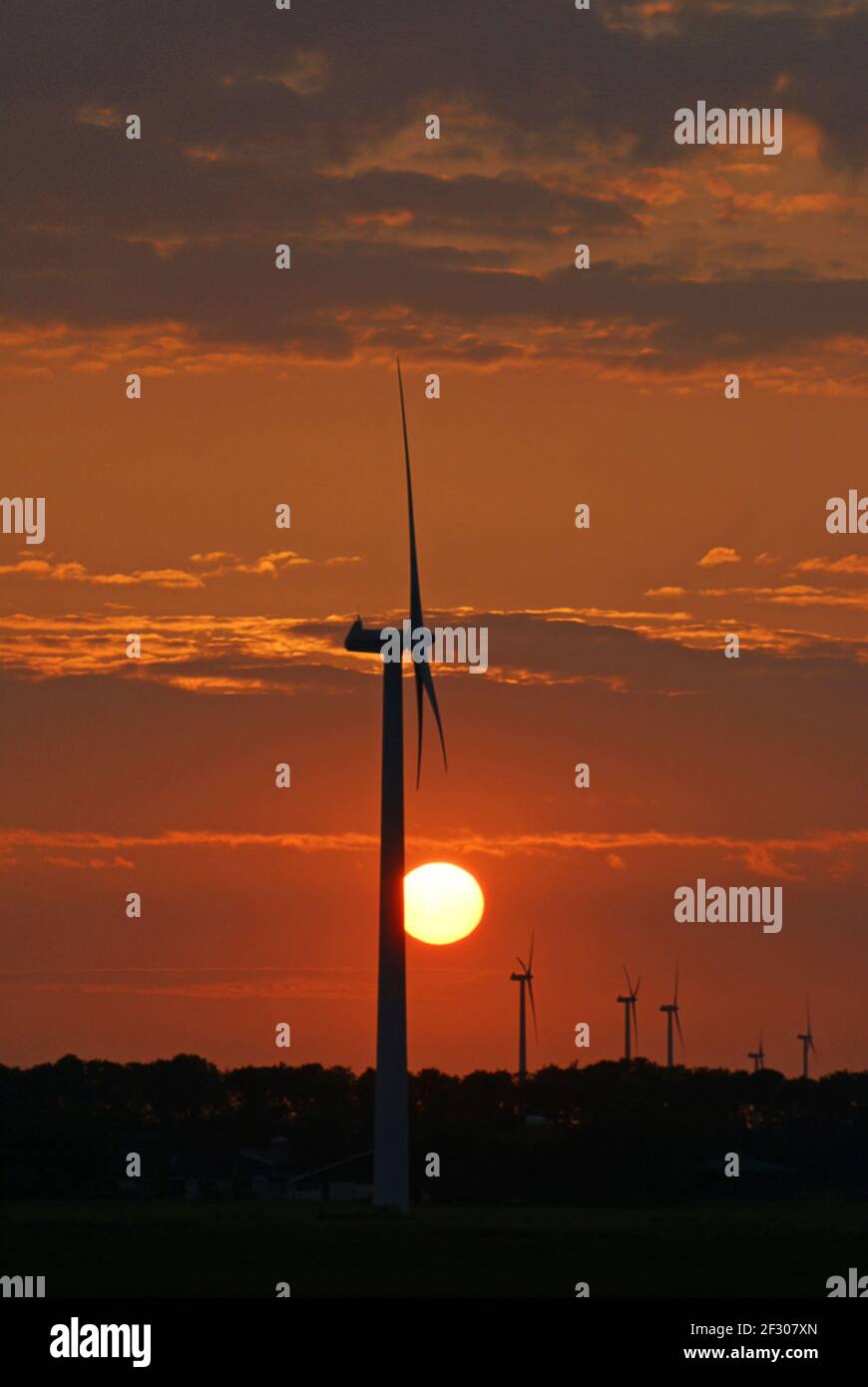 Beautiful orange sunset behind wind turbines Stock Photo