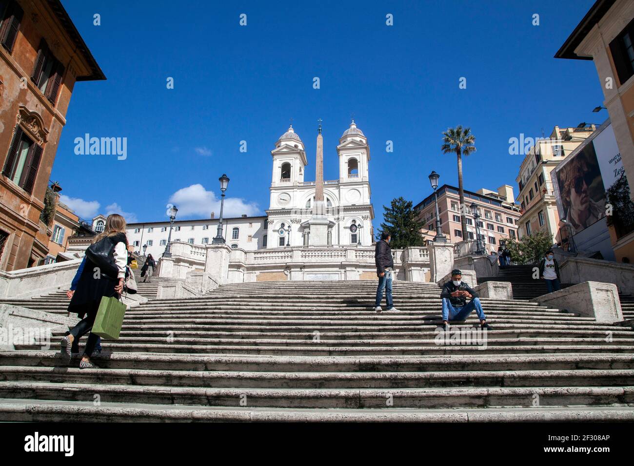 Rome, ITALY- 13 March 2021: People enjoy a sunny day by the Spanish Steps on Piazza di Spagna in downtown Rome before the government tightens restrictions across most of the country from March 15, facing a 'new wave' of Covid-19 Stock Photo